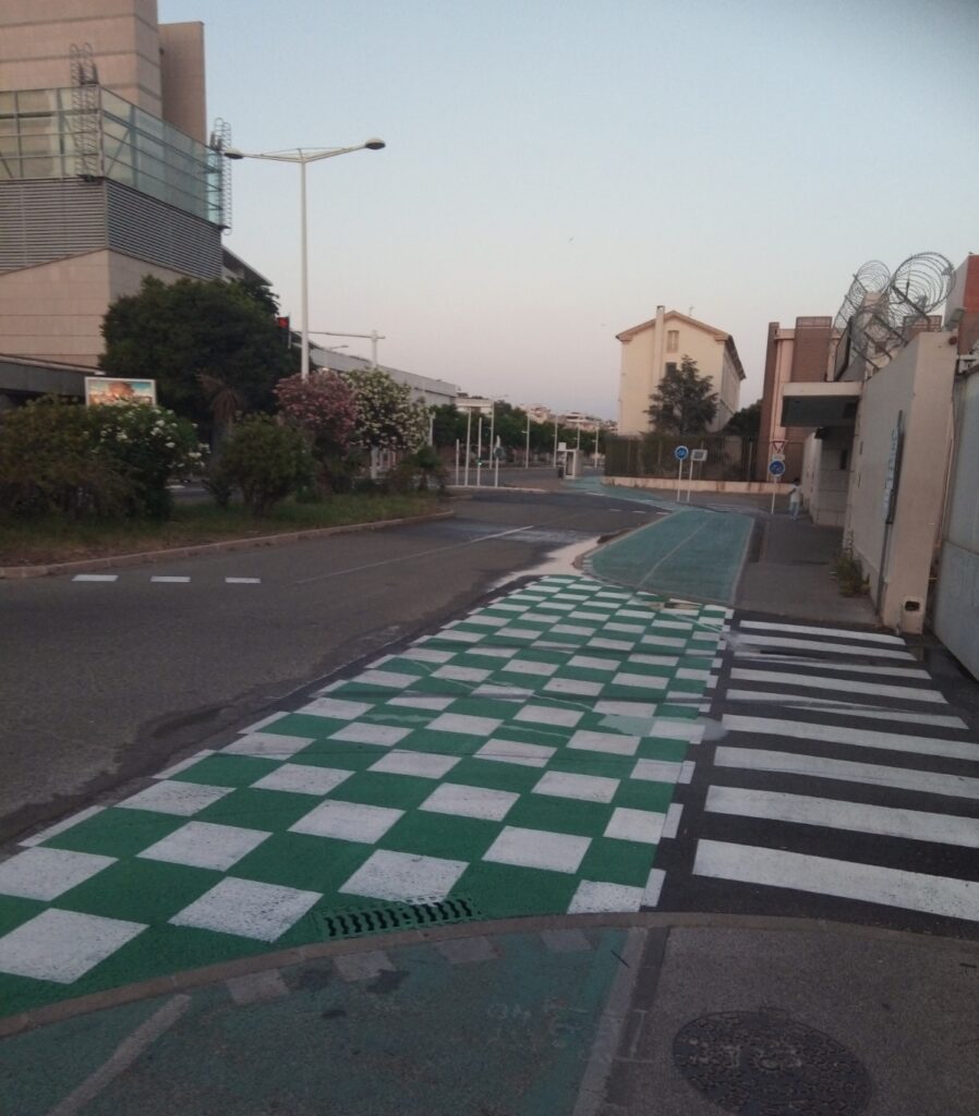 Photo de l'entrée Castigneau de l’arsenal de Toulon. La piste cyclable qui longe la base a été peinte d'un damier vert et blanc bien visible.
