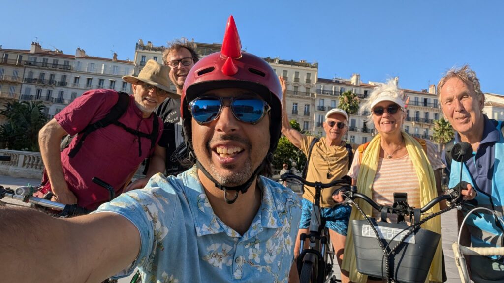 Un groupe de six personnes à vélo, devant la fontaine place de la liberté, à Toulon.